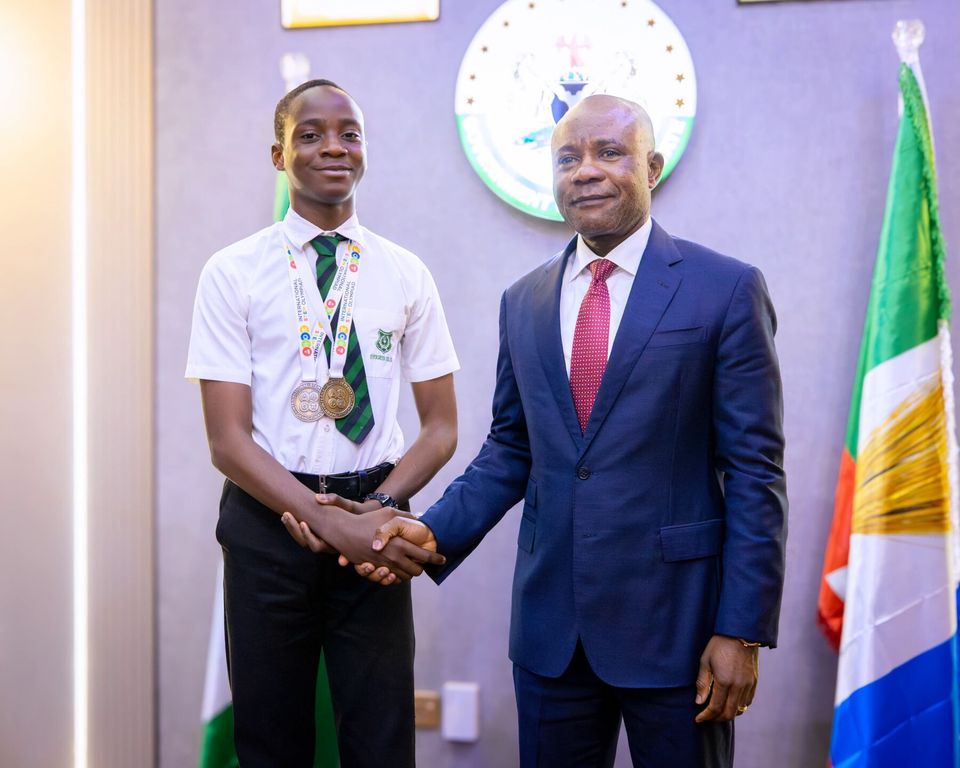 A student medallist shaking hands with an official, July 2026