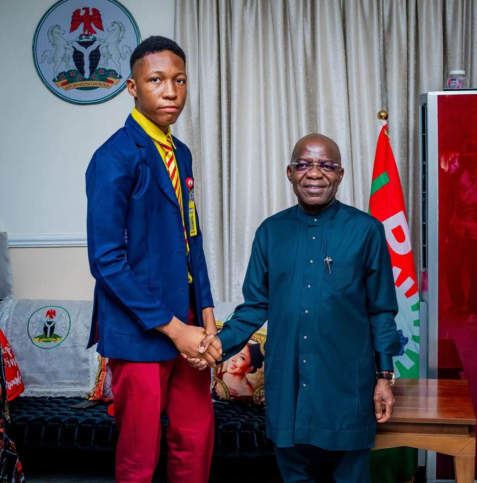A student medallist with an official at Government House, July 2026