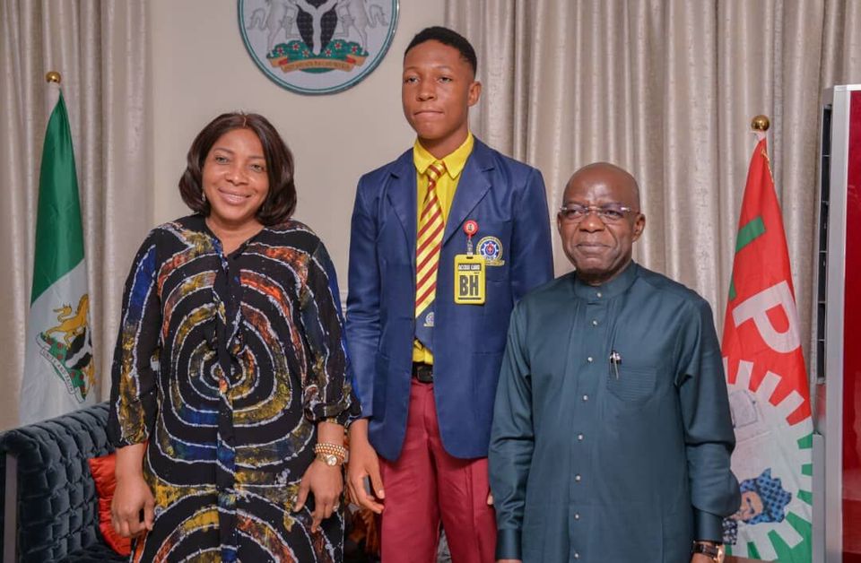 A student medallist with officials, July 2026